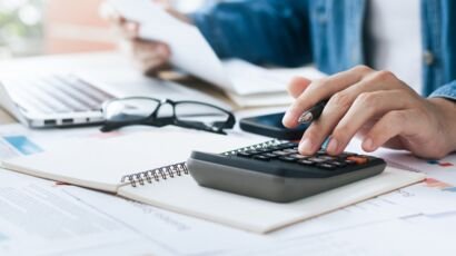 Investors are calculating profits and costs with calculators, growth and investment chart analysis, business planning and strategies to maximize sales profits. Long term business plan.